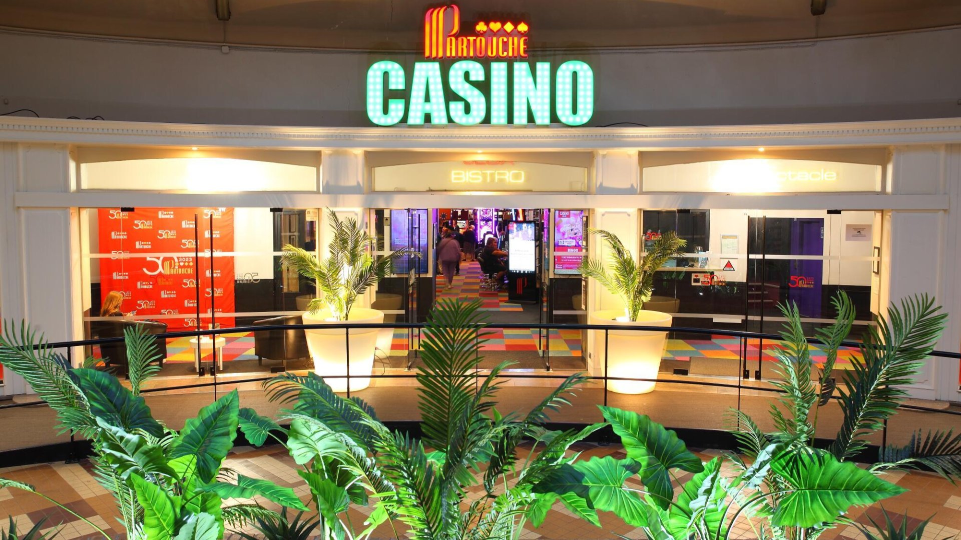 Entrée du Casino Partouche de Calais entourée de verdure